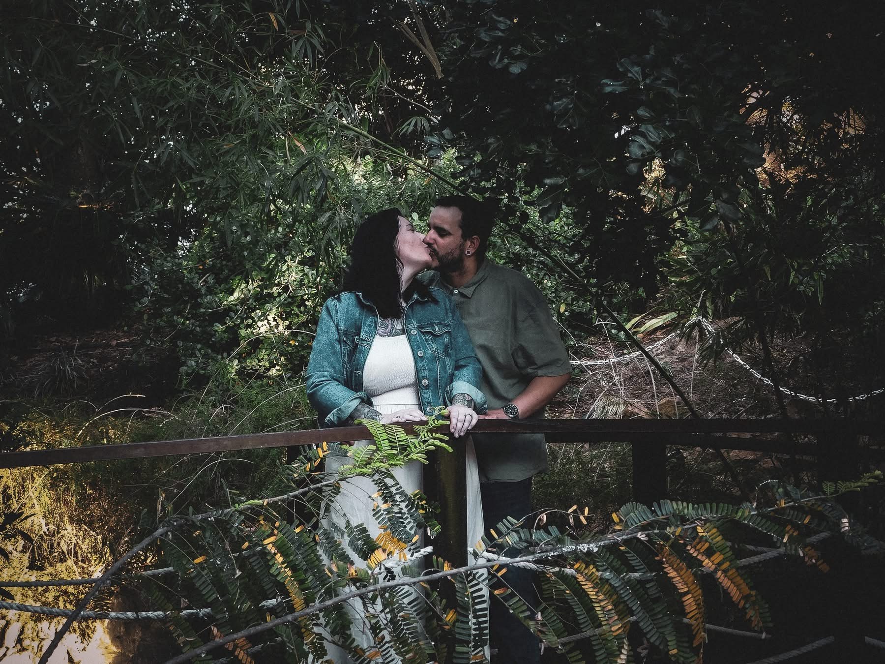 Couple sharing a kiss on a garden bridge